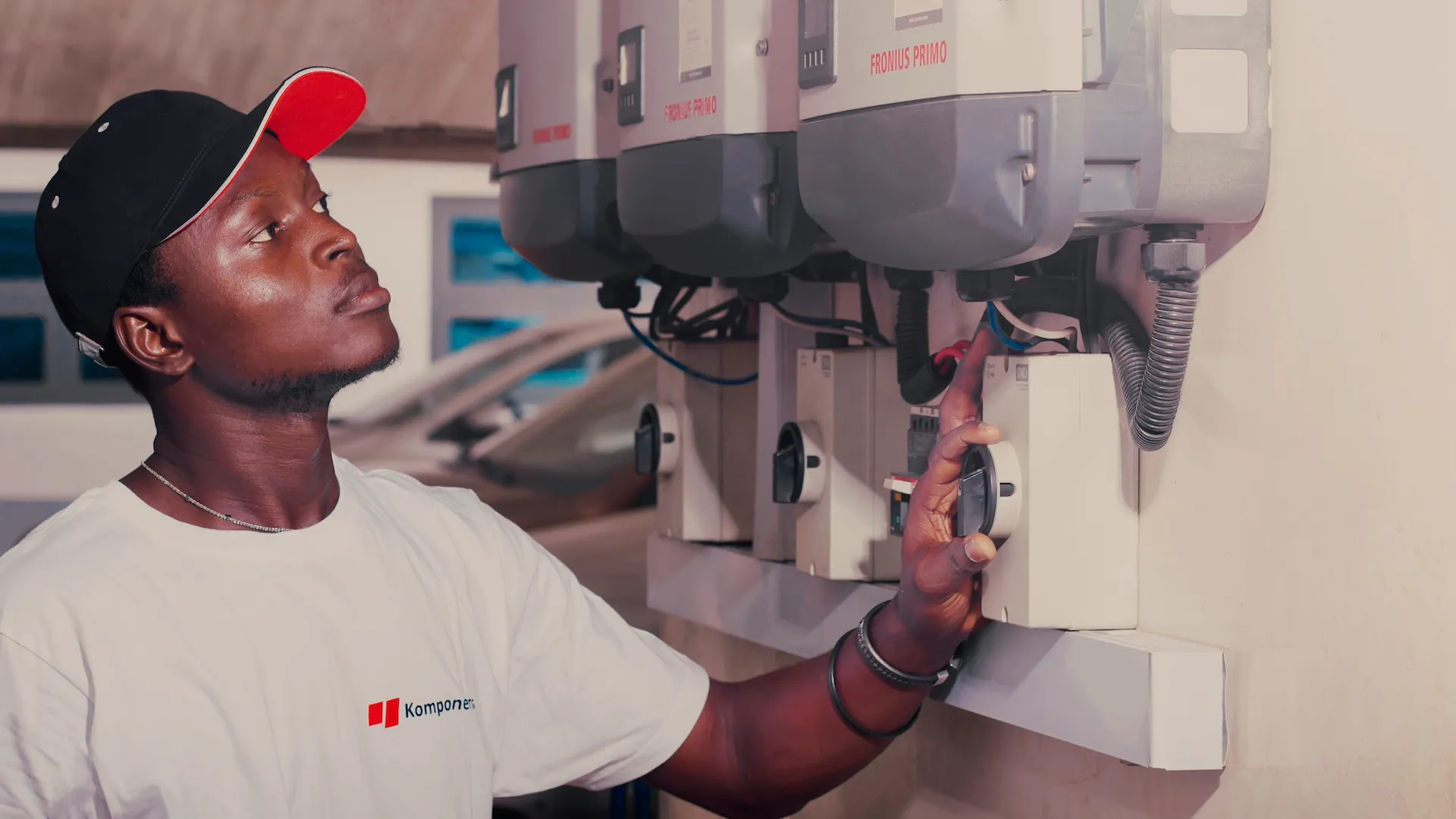 Komponents' technician examining a Fronius wall-mounted unit